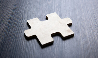 One puzzle piece on a wooden background