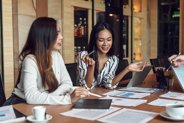 Group Asian businesswoman ​are enjoying success working together brainstorm analytical ideas using graph tablet documents at the office