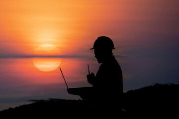Engineer silhouette working against sunset backdrop