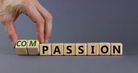 Passion or compassion symbol. Businessman turns cubes, changes the word compassion to passion. Beautiful grey table, grey background, copy space. Business, passion or compassion concept.