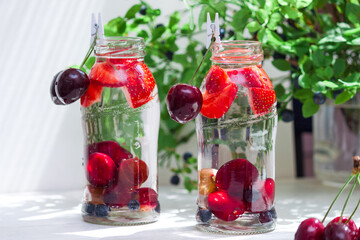 Variety of fruit with detox water in glass small bottles. Refreshing summer drinks. Healthy diet concept.