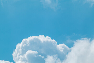 Fluffy white high clouds framing bright blue sky, cloudscape background with copy space. Skyscape natural heavenly scenery