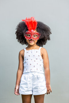girl hairstyle afro wearing red fancy mask show emotion and gesture lonely on a gray background Childhood concepts and emotions
