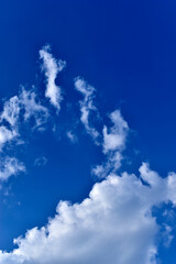White cumulus cirrus clouds in a blue sky