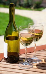 Bottle and glasses of white wine outdoors