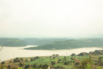 Lake fringed by mountains and hills shrouded in mist in Mexico state Coal Village