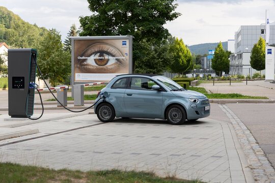 Oberkochen, Germany Bavaria 08-16-2021 : Fiat 500e Icon Convertible charging the batteries at an ENBW Quick-Charger in front of the forum building of the Zeiss company.