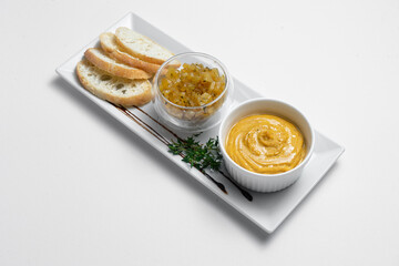 close up of goose liver pate with apple chutneys and bread on white background