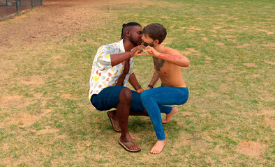 LGBTQ men couple in love kissing in the park on green grass 3d