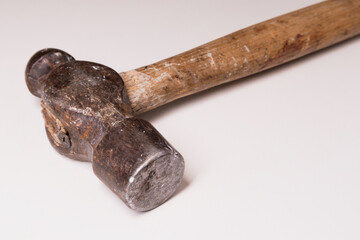 An old, used hammer close-up on a white background. Soft focus