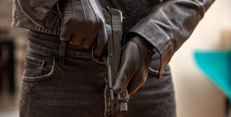 Gloved hand holding a pistol closeup view