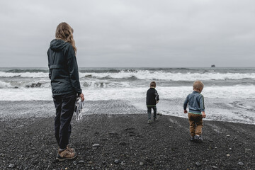 Mother and sons at the water's edge on Rialto Beach in Olympic National Park