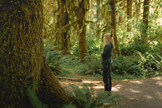 Young woman enjoying a quiet moment on a hike in the Hoh Rainforest in Olympic National Park