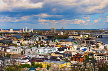 Scenic aerial landscape view of ancient Podil neighborhood with old colorful buildings. Skyscrapers in Obolon neighborhood on the background. Springtime in big city