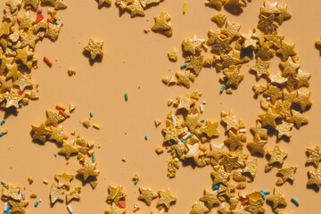 background of Christmas confetti on a beige background