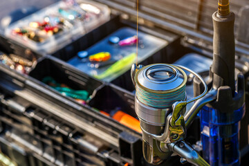 A large fisherman's tackle box fully stocked with lures and gear for fishing.fishing lures and accessories in the box background. - obrazy, fototapety, plakaty