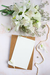 wedding card design. bouquet of white flowers on a white background and wedding rings 