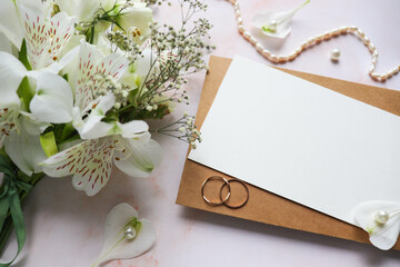 wedding card design. bouquet of white flowers on a white background and wedding rings 