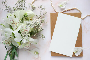 wedding card design. bouquet of white flowers on a white background and wedding rings 
