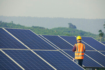 Worker holding tablet to inspect solar cells,technician checking solar panels,Clean energy or alternative energy concept