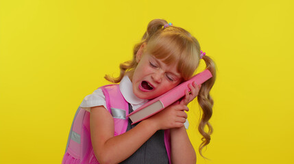 Portrait of tired schoolgirl wears backpack yawning, sleepy inattentive feeling somnolent lazy bored gaping suffering from lack of sleep. Isolated over yellow studio background. Back to school concept