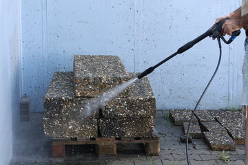 The worker washes the plates with a jet of water