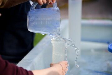 water pouring into jug in a nursery water tray