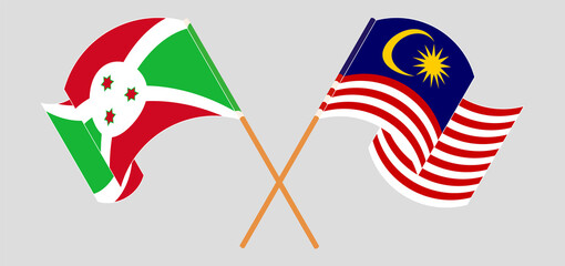 Crossed and waving flags of Burundi and Malaysia