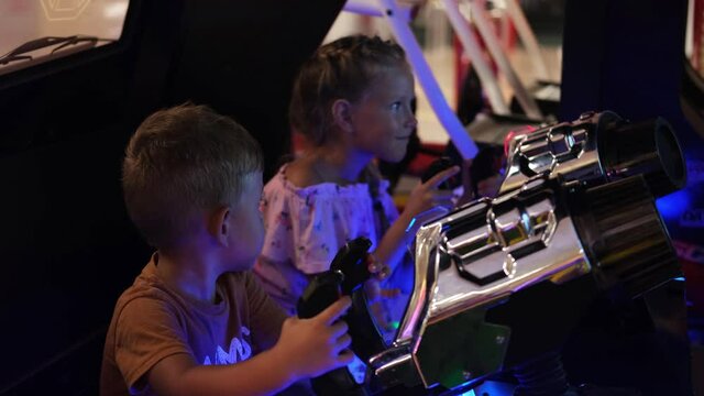 The kids is playing a slot machine. Creativity Game concept. Little boy and girl play a virtual game, shooting a pistol. Family weekend.