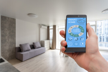 Smart home control on phone. Phone in woman hand. Living room interior in background