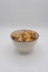 Bol de cereales en fondo blanco, vista frontal.