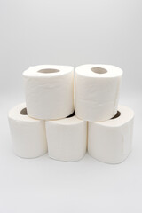 Rollos de papel higiénico en torre, fondo blanco.