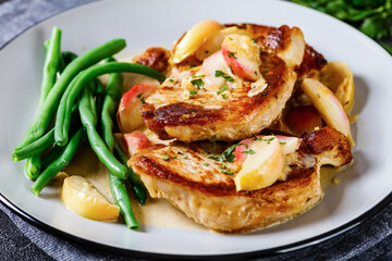 pork chops in apple cider cream sauce on a plate