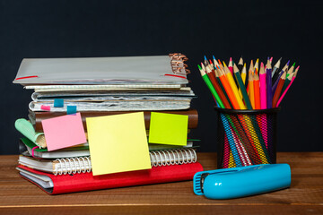 Many different notebooks and folders on the table. Jar of pencils. Stapler. Blank stickers for...