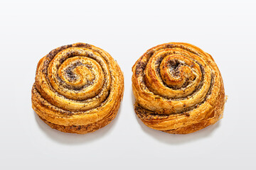 Sweet puff buns with poppy seeds on a light background