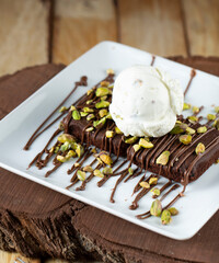 cake with white ice crean on the plate with nuts