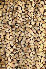 Heap of chopped firewood in pile close-up. Firewood storage close up. Stock of wooden logs. Chopped wood in bright sunlight. Rustic lifestyle. Woodpile with firewood full frame image. Wooden texture.