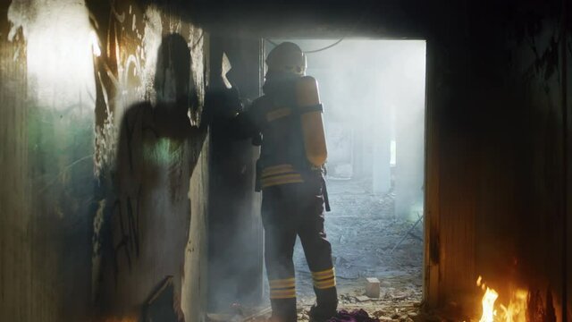 Unrecognizable fireman breaking doorway with axe