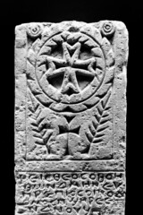 Black and white photo of ancient christian symbol and text carved on marble