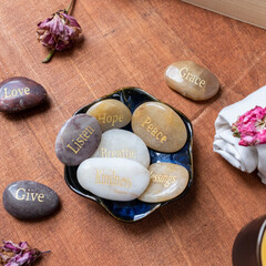 Motivational inspirational stones with writings. Serenity, gratitude, passion, love on a red table background