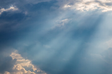 Sun rays through thick evening clouds. Beautiful view of natural colorful background.
