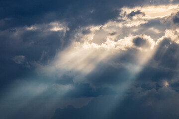 Sun shining through thick clouds. Bright view of natural colorful background.
