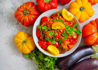 stewed eggplant, tomato, pepper on a concrete background