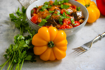 stewed eggplant, tomato, pepper on a concrete background