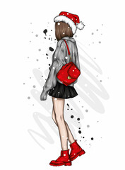 A beautiful girl in stylish clothes and a New Year's hat. New Year and Christmas, Santa Claus. Fashion & Style.