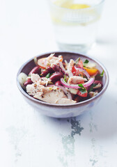 Salad with tuna and cherry tomatoes. Wooden background. Close up. Copy space.