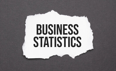 business statistics sign on the torn paper on the black background