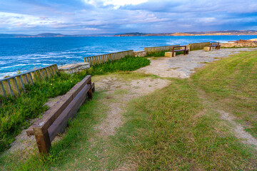 Wooden benches in Hercules Tower coast (La Coruna, Spain).