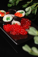 Sushi roll with reflection on a black background. Japanese kitchen and restaurant. 