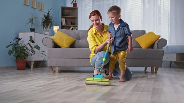 parent-child relationship, adorable little boy helps his female parent mop floor while cleaning house